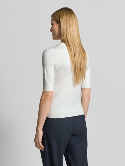 Vrouwenmodel draagt Slim Fit T-Shirt aus Viskose-Mix van s.Oliver RED LABEL in fijngebreide witte strickoptiek, korte mouw, ribboord, label-applicatie, ganzlichaamsaanzicht achteraan.