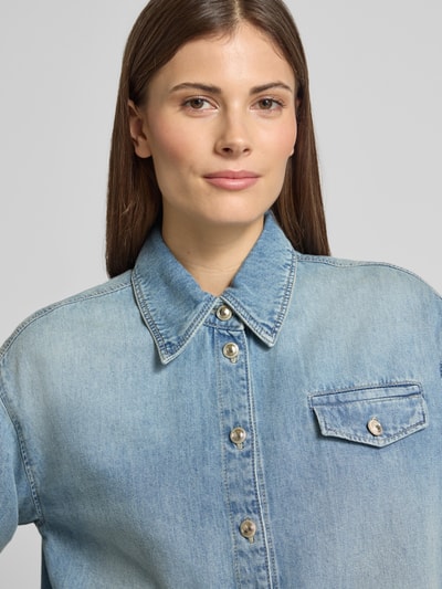 Kobiece modelka ma na sobie Boxy Fit Jeansbluse mit Brusttasche od Luisa Cerano z mieszanki bawełny i lyocellu, jasnoniebieski denim, widoczna kieszeń na piersi, kołnierzyk koszulowy, zapięcie na guziki, tekstura gładka, ujęcie: zbliżenie górnej części ciała.