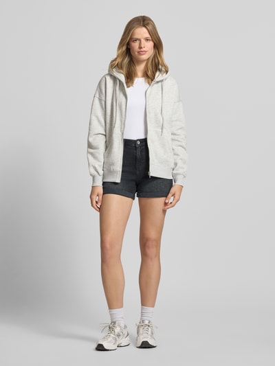 Frauenmodel trägt Regular Fit Jeansshorts aus Baumwoll-Mix Modell 'JOSEPHINE' von Only in klassischer Denim-Optik mit Label-Patch, 5-Pocket-Design, Knopf und verdecktem Reißverschluss, dunkle Farbgebung, feste Struktur, Ganzkörperansicht von vorne.