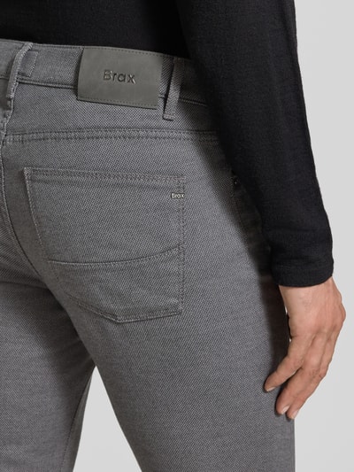 Männermodel trägt Stoffhose aus Baumwoll-Mix mit Viskose-Anteil Modell 'Cadiz' von Brax, Melange-Optik in Grau, Detailaufnahme Rückansicht.
