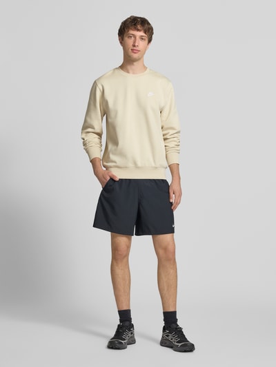 Männermodel trägt Sweatshirt mit Label-Stitching und Rundhalsausschnitt von Nike in Beige, Regular-Fit, Baumwoll-Mix, Ganzkörperansicht von vorne. Rückenlänge bei Größe M: 69 cm, Ärmellänge bei Größe M: 71 cm.