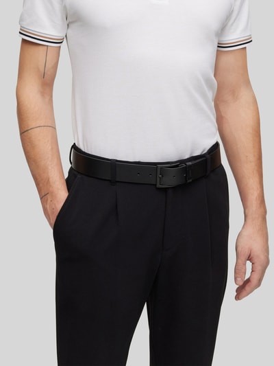 Mannenmodel draagt Ledergürtel mit Dornschließe Modell 'CONNIO' van BOSS, mat zwart leer, 4 cm breed, detailopname taille