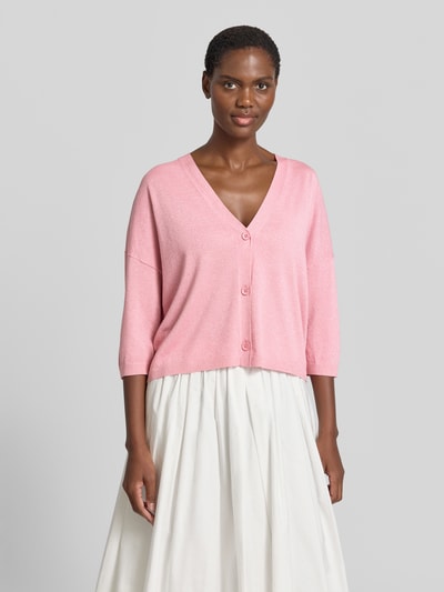 Frauenmodel trägt Relaxed Fit Cardigan aus Viskose-Mix in Strick-Optik von Comma, rosa Farbe, V-Ausschnitt, 3/4-Arm, Knopfleiste, überschnittene Schultern, Rückenlänge bei Größe S 52 cm, Ärmellänge 26 cm, Ganzkörperansicht von vorne.
