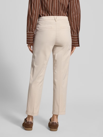 Frauenmodel trägt Chino mit Eingrifftaschen von MAC, beiger Baumwoll-Elasthan-Mix, Regular Fit, Gesäßtaschen, Ganzkörperansicht Rückansicht.