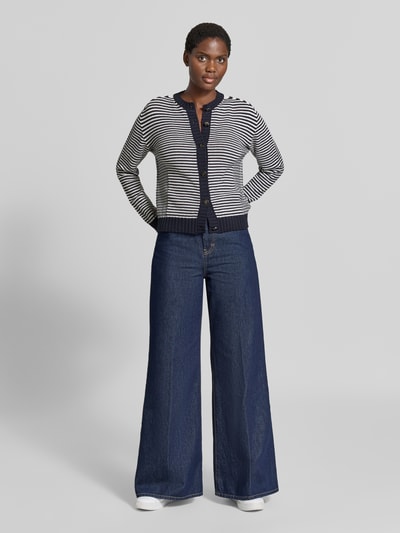 Frauenmodel trägt Strickjacke aus Baumwoll-Mix von Emporio Armani mit schmaler Passform, Knopfleiste und elastischen Abschlüssen, blau-weiß gestreift, kombiniert mit weiter Jeans, Rückenlänge 53 cm, Ärmellänge 65 cm, Ganzkörperansicht von vorne.