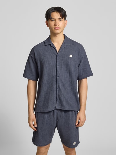 Mannelijk model draagt Regular Fit vrijetijdsoverhemd met labelpatch model 'LIBCO' van Pegador in blauw materiaalmix met katoen, reverskraag en knoopsluiting, korte mouw, vooraanzicht bovenlichaam
