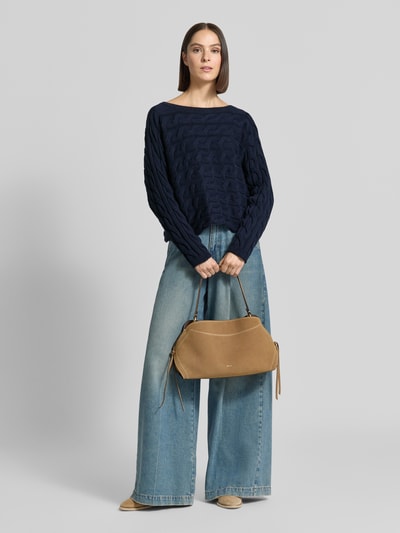 Frauenmodel trägt Relaxed Fit Strickpullover aus Baumwoll-Mix mit Zopfmuster von Oui, U-Boot-Ausschnitt, dunkelblau, Jeans, Ganzkörperansicht von vorne.