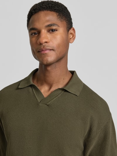 Mannelijk model draagt Regular Fit poloshirt uit puur katoen model 'KOCELLO' van BOSS Orange, look: effen, structuurpatroon, labelpatch, polokraag, V-hals, korte mouw, mouwboord en rompzoom geribd, materiaalverwerking: knitwear, materiaal: katoen. Nahaufnahme bovenlichaam.