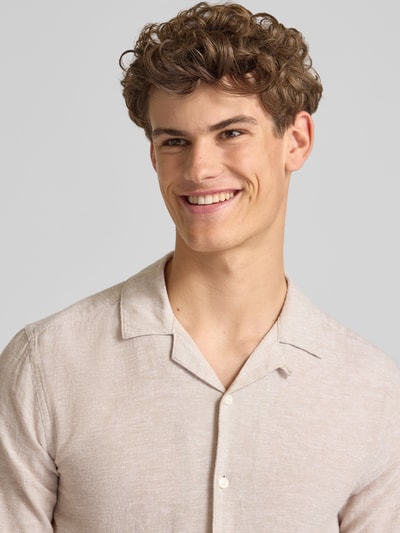 Męskimodel nosi koszulę casualową Slim Fit Freizeithemd aus Baumwoll-Leinen-Mix Modell 'CAIDEN' von Only & Sons, melanż, krój slim fit, kołnierz z połami, jednorzędowa listwa guzikowa, naszywka z logo, krótki rękaw, materiał: mieszanka bawełny i lnu, zbliżenie na górną część ciała