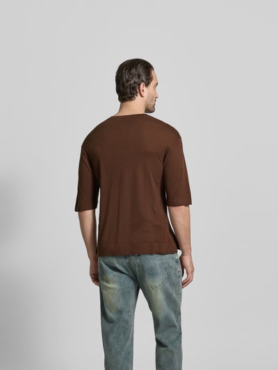 Männermodel trägt Relaxed Fit T-Shirt aus Lyocell-Woll-Mix von Officine Générale in Braun, semitransparent, Halbarm, Ganzkörperansicht Rückansicht.