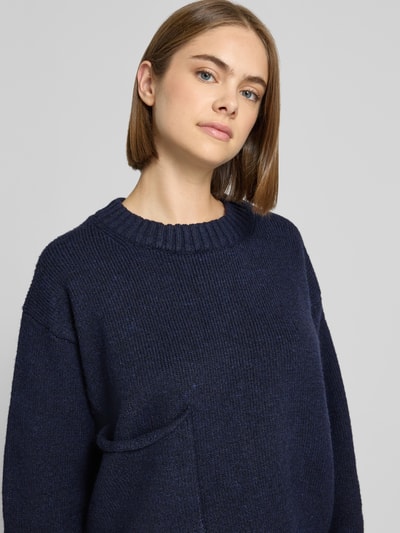 Vrouwenmodel draagt gebreide pullover met opgestikte zak Model 'FRANKIE' van Topshop, donkerblauw, met wol, relaxed fit, ronde hals, Nahaufnahme Oberkörper.