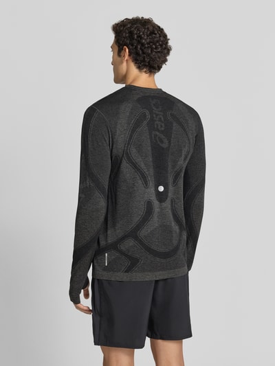 Männermodel trägt Longsleeve mit Logo-Print und Rundhalsausschnitt von ASICS, dunkle Farben, glatte Struktur, gerader Schnitt, Ganzkörperansicht Rückansicht. Rückenlänge bei Größe M 70 cm, Modell ROAD SEAMLESS.