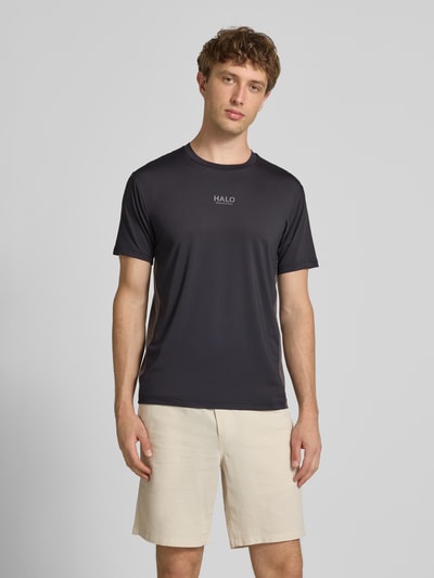Männermodel trägt Herren T-Shirt mit Logo Modell 'DIVISION' von HALO, Material-Mix mit Stretch-Anteil, Regular-Fit, Rundhalsausschnitt, Schwarz, Rückenlänge bei Größe M 69 cm, Ganzkörperansicht von vorne.