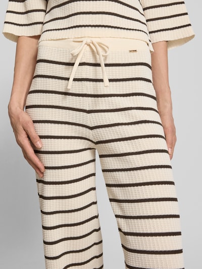 Frauenmodel trägt Wide Leg Hose aus Viskose-Mix Modell 'NURIA' von VILLA SOPHIE, Optik:Allover-Muster, Nahaufnahme Oberkörper.
