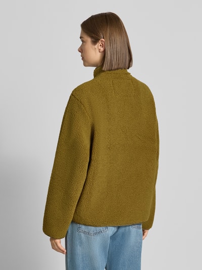Frauenmodel trägt Teddyjacke mit Stehkragen Modell 'VERA' von JJXX in Olivgrün, strukturierte Oberfläche, Ganzkörperansicht Rückansicht. Damen Teddyjacke von JJXX, gerade Passform, seitliche Eingrifftaschen, elastische Abschlüsse.