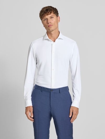 Männermodel trägt Slim Fit Business-Hemd mit Haifischkragen von Jake*s, weiß, feines Strukturmuster, Material-Mix mit Stretch-Anteil, Ganzkörperansicht von vorne. Rückenlänge 78 cm, Schulterbreite 48 cm, Ärmellänge 68 cm bei Größe 39/40.
