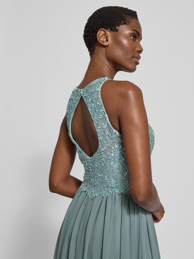 Vrouwenmodel draagt Avondjurk met florale borduursel en siersteentjes van LAONA, Amerikaans hals, cut-out op rug, meerlaagse rok, gewatteerde cups, getailleerde pasvorm, duurzaam materiaal; detailopname schouder en rug.