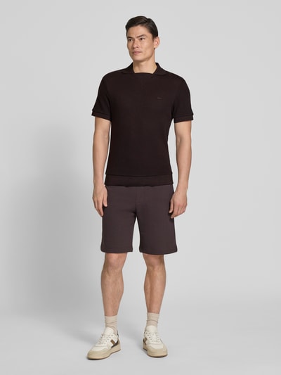 Männermodel trägt Regular Fit Poloshirt aus reiner Baumwolle von Lacoste, unifarben, Strukturmuster, Johnny-Kragen, Ganzkörperansicht von vorne.