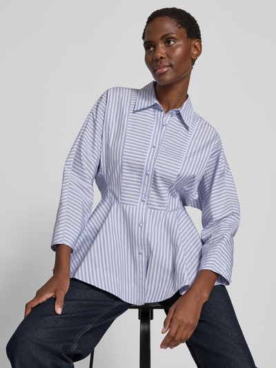 Vrouwenmodel draagt blouse in getailleerd model SCALIGA van Marella, all-over look, overhemdkraag, knoopsluiting, vooraanzicht heuphoogte.
