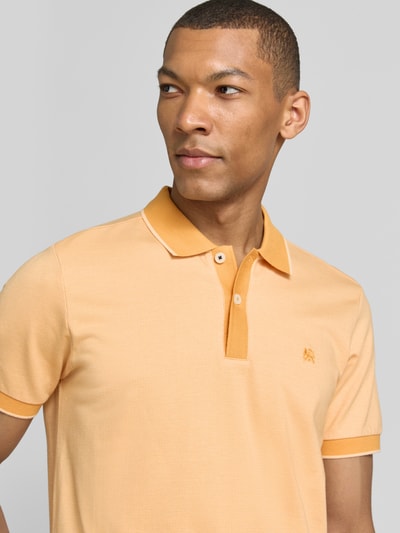 Männermodel trägt Regular Fit Poloshirt mit Logo-Stitching von Lerros in Hellorange, Polokragen, kurze Knopfleiste, Nahaufnahme Oberkörper.