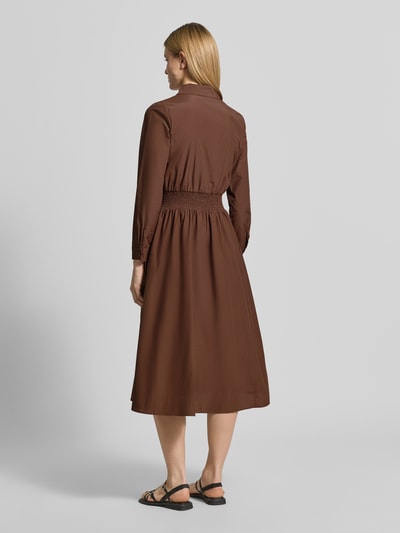 Frauenmodel trägt Hemdblusenkleid mit Reißverschluss Modell 'NETTI' von Soyaconcept in Braun, Material-Mix, A-Linie, Midikleid, elastisches Taillenband, Rückenlänge bei Größe S 121 cm, Brustweite 42 cm, Ärmellänge 60 cm, Ganzkörperansicht Rückansicht.