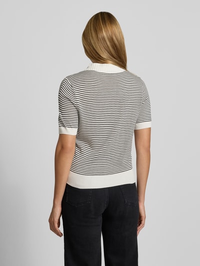 Frauenmodel trägt Poloshirt mit gerippten Abschlüssen von MANGO, schwarz-weiß gestreift, kurzärmelig, gerade Passform, Ganzkörperansicht Rückansicht.