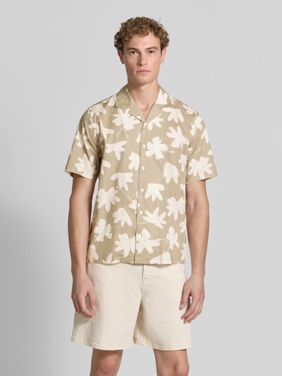 Männermodel trägt Regular Fit Freizeithemd aus Baumwoll-Mix Modell 'Klampo' von Matinique, beige mit weißen Blattformen, Kurzarm, Knopfleiste, Reverskragen, lockerer Schnitt, Vorderansicht, Ganzkörperansicht von vorne. Elastischer Baumwoll-Mix, Rückenlänge 73 cm, Schulterbreite 45 cm, Ärmellänge 27 cm.