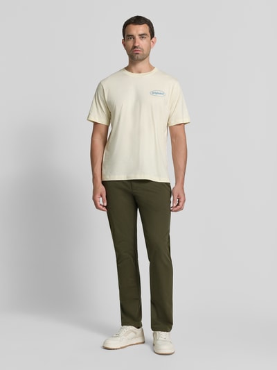 Männermodel trägt Tapered Fit Hose mit Gesäßtaschen von MCNEAL in Olivgrün mit Eingrifftaschen, Knopf- und Reißverschluss, Ganzkörperansicht von vorne. Bundweite bei Größe M: 45 cm, Innenbeinlänge bei Größe M: 80 cm.