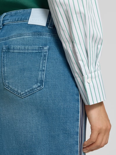 Frauenmodel trägt Regular Fit Midirock in Denim-Optik mit Gehschlitz von Marc Cain, Baumwoll-Mix, 5-Pocket-Design, Detailaufnahme Rückansicht.