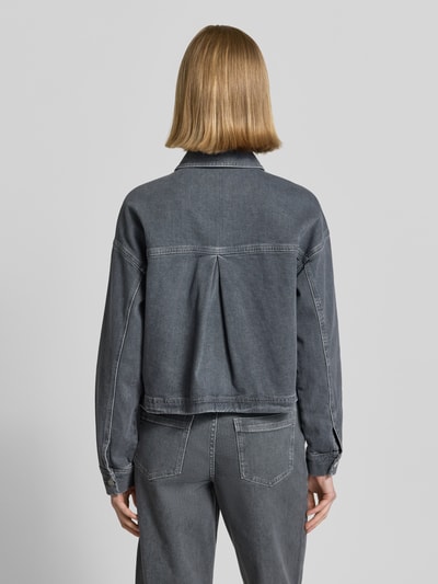 Frauenmodel trägt Boxy Fit Jeansjacke mit aufgesetzten Taschen Modell 'Niandra' von Someday aus reiner Baumwolle, Rückansicht, Ganzkörperansicht.