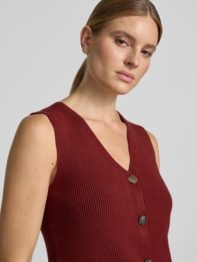 Kobiece model nosi bordową kamizelkę o fakturze prążkowanej z guzikami, Regular Fit Weste aus Viskose-Mix Modell 'KANITA' od Soyaconcept, zbliżenie na górną część ciała