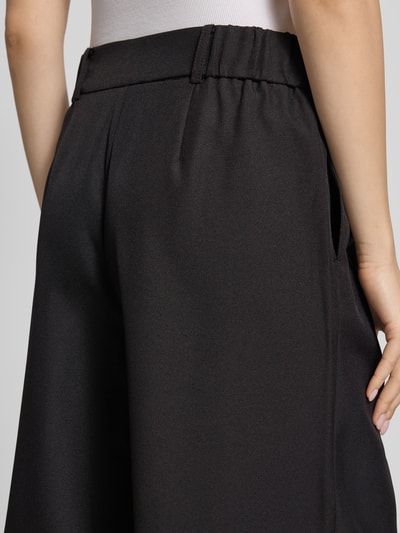 Frauenmodel trägt Regular Fit Bermudas mit Bundfalte Modell 'LINDA' von Only in Melange-Optik, Webware, seitliche Eingrifftaschen, Nahaufnahme Rückansicht.
