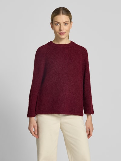Vrouwenmodel draagt gebreide pullover met Raglanmouwen van FREE/QUENT in bordeauxrood, recht model, materiaalmix met wol, ronde hals, ruglengte maat S 54 cm, mouwlengte maat S 50 cm, Ganzkörperansicht van voren.