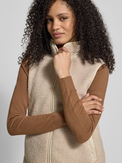Frauenmodel trägt Fleeceweste mit Stehkragen Modell 'SIV' von Didriksons, Regular-Fit, Reißverschluss, beige Textur, Nahaufnahme Oberkörper. Rückenlänge 67 cm, Schulterbreite 38 cm, Brustweite 48 cm bei Größe 36.