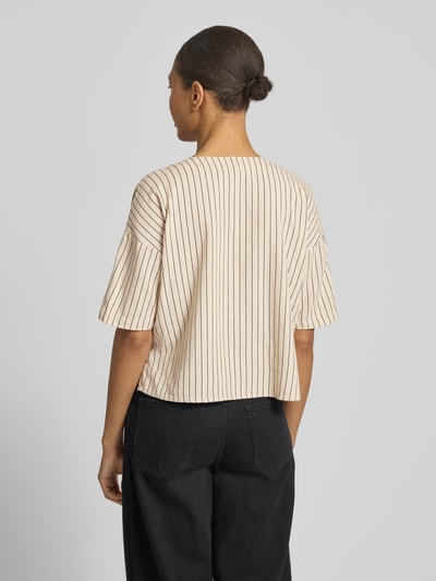 Männermodel trägt Boxy Fit Hemdbluse aus Viskose-Leinen-Mix Modell 'MYMILO' von Vero Moda, beżowe tło, czarne paski, flammgarn, tunikowy kołnierz, dekolt w serek, rękaw 3/4, Ganzkörperansicht Rückansicht.