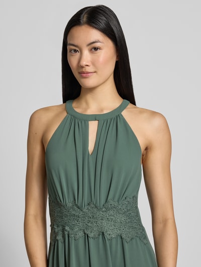 Vrouwenmodel draagt avondjurk met tailleband Model 'MILINA' van VILA, groen chiffon, getailleerd model, druppelvormige hals, Nahaufnahme Oberkörper.