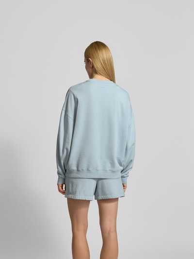 Frauenmodel trägt Oversized Sweatshirt mit Logo-Detail von Anine Bing aus reiner Baumwolle, oversized Fit, Rückenlänge bei Größe S 65 cm, Ganzkörperansicht Rückansicht.