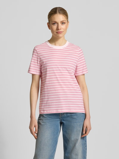 Kobiece model prezentuje Regular Fit T-Shirt aus reiner Baumwolle Modell 'PAULINA' od Vero Moda, różowo-białe paski, jersey, krój regular fit, widok z przodu całej sylwetki.