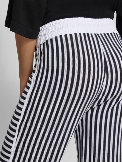 Frauenmodel trägt Hose im Allover-Look mit elastischem Bund und Tunnelzug von Marc Cain, Reine Baumwolle, Strukturmuster, Nahaufnahme Rückansicht.
