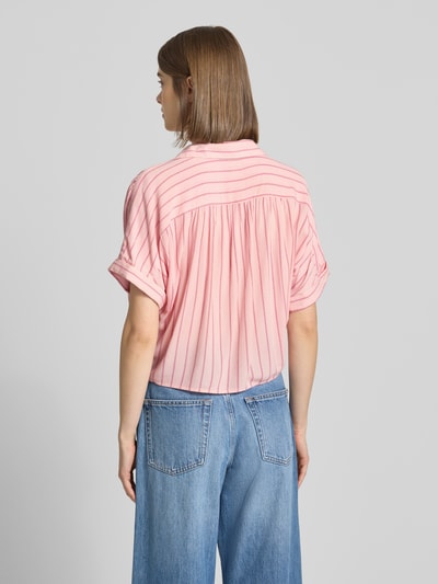 Frauenmodel trägt Regular Fit Hemdbluse aus reiner Viskose Modell 'PAULA' von Only, gestreiftes Muster in Rosa, Ganzkörperansicht Rückansicht.
