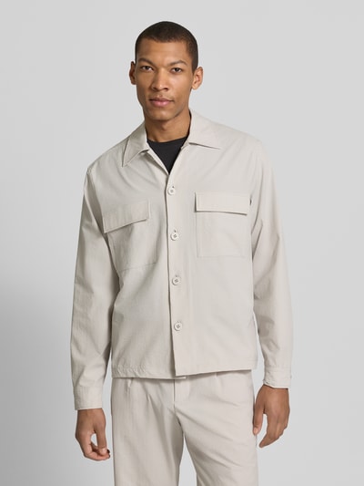 Mężczyzna model nosi Regular Fit Hemdjacke mit Brusttaschen od JAKE*S STUDIO MEN, elastyczny materiał, krój regular fit, kolor jasny, przód z guzikami, kieszenie na piersi, widok całej sylwetki z przodu