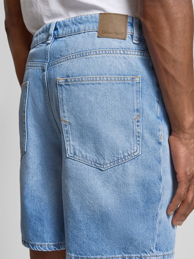 Männermodel trägt Loose Fit Jeansshorts aus Baumwoll-Lyocell-Mix Modell 'ALEX' von SELECTED HOMME, hellblau, Denim, Detailaufnahme Rückansicht.