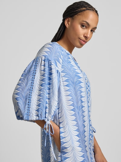 Frauenmodel trägt Knielanges Tunikakleid aus Viskose-Mix mit V-Ausschnitt von Christian Berg Woman Selection, blau-weiß gemustert, A-Linie, 1/2-Arm mit Schnürung, Nahaufnahme Oberkörper.
