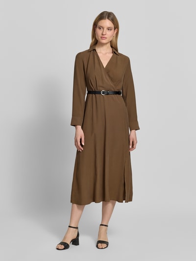 Modelka nosi sukienkę midi w kopertowym stylu z paskiem, mieszanka wiskozy, linia a, wykładany kołnierz, dekolt w serek, długość tyłu 128 cm, szerokość w rozmiarze 36: 37 cm, długość rękawów 62 cm, 'Midikleid in Wickel-Optik mit Gürtel' od Jake*s Collection, brązowy kolor, gładka tekstura, pełny widok z przodu.