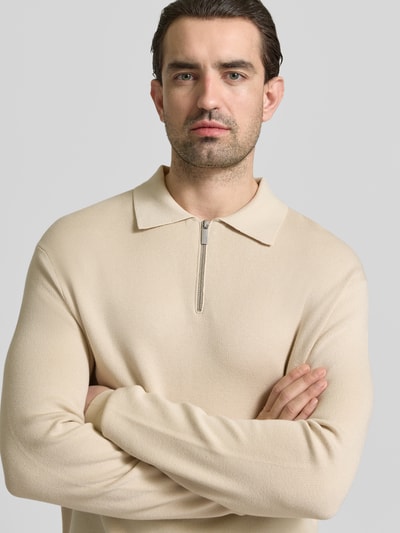 Männermodel trägt Relaxed Fit Pullover aus Viskose-Mix Modell 'TELLER' von SELECTED HOMME in Beige, Feinstrick, Nahaufnahme Oberkörper.