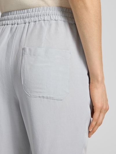 Frauenmodel trägt Straight Fit Stoffhose aus Viskose-Mix mit Leinen-Optik von Marc Cain, helle Farbe, sichtbarer elastischer Bund, Eingrifftasche, Detailaufnahme Hüfte, Damen Stoffhose, Tunnelzug, Bundweite 37 cm, Innenbeinlänge 66 cm, Größe 36