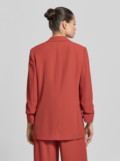 Frauenmodel trägt Oversized Blazer mit Raffungen von Jake*s Collection in Rostrot, Elastischer-Material-Mix, Oversized-Fit, Rückenlänge 70 cm, Ganzkörperansicht Rückansicht.