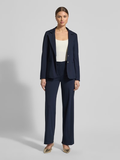 Vrouwenmodel draagt Slim Fit Blazer uit viscosemix model 'Ritmo' van Marella in donkerblauw, reverskraag, paspelzakken, dubbel rij knopen, elastisch materiaal, frontale lichaamsopname.