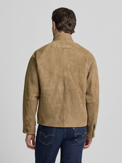 Mężczyzna nosi Regular Fit Lederjacke aus echtem Ziegenleder Modell 'LORIDGE' od HUGO w kolorze jednolitym, stehkraag, zamszowa tekstura, długie rękawy, kieszenie z klapką; widok całej sylwetki od tyłu.