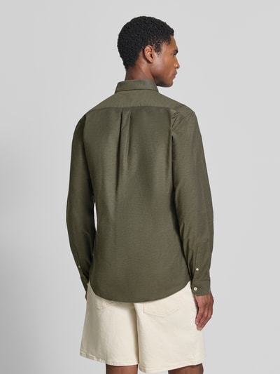 Männermodel trägt Regular Fit Freizeithemd aus Baumwoll-Mix Modell 'Oxford' von Lindbergh in Olivgrün, Rückenansicht, Ganzkörperansicht Rückansicht. Baumwoll-Elasthan-Mix, Button-Down-Kragen, 1-Knopf-Manschetten, abgerundeter Saum, Rückenlänge 77 cm, Schulterbreite 44 cm, Ärmellänge 66 cm.